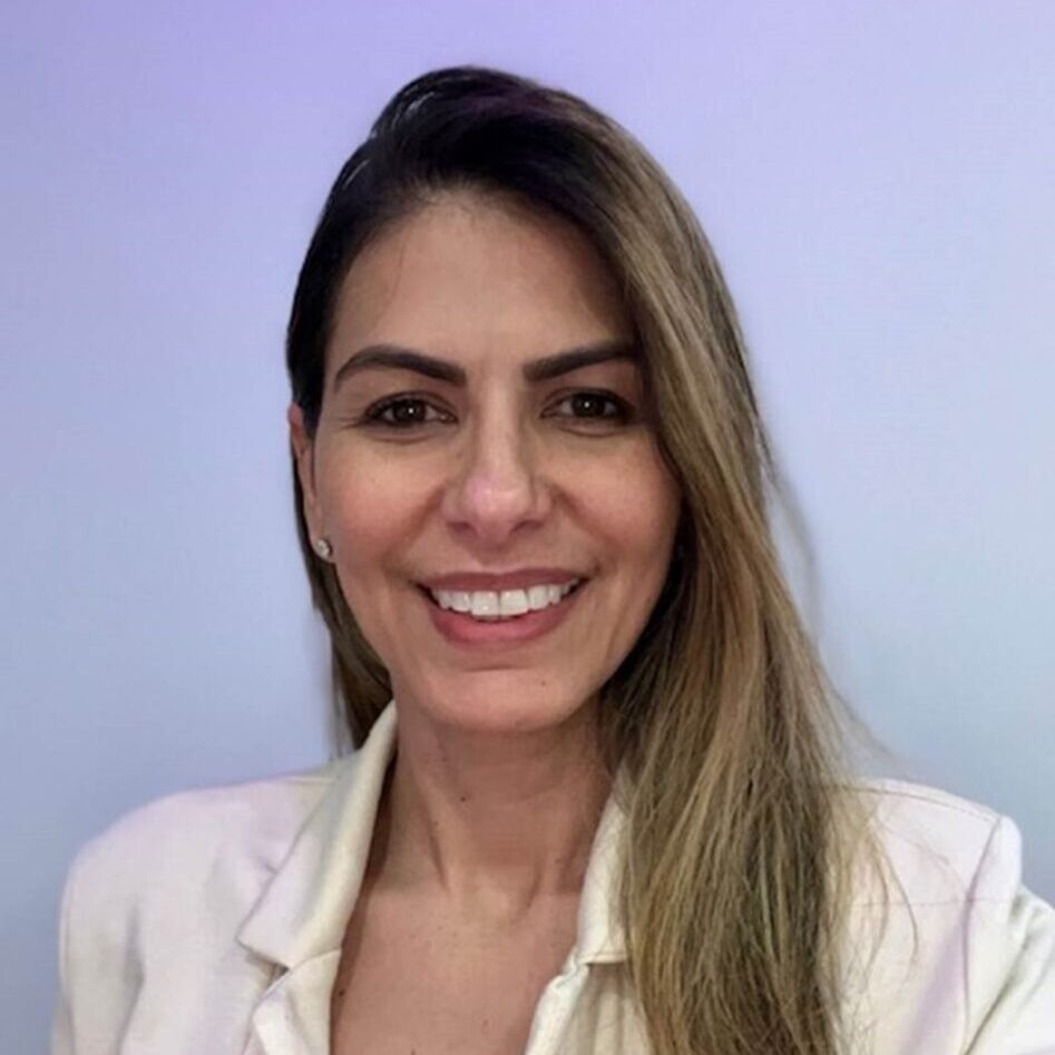 A woman with long hair and white shirt smiling.